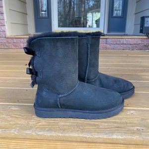 Beautiful and cozy black Uggs with ties on the back of them.